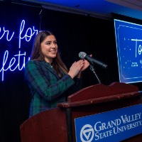 Girl stands in front of microphone and claps